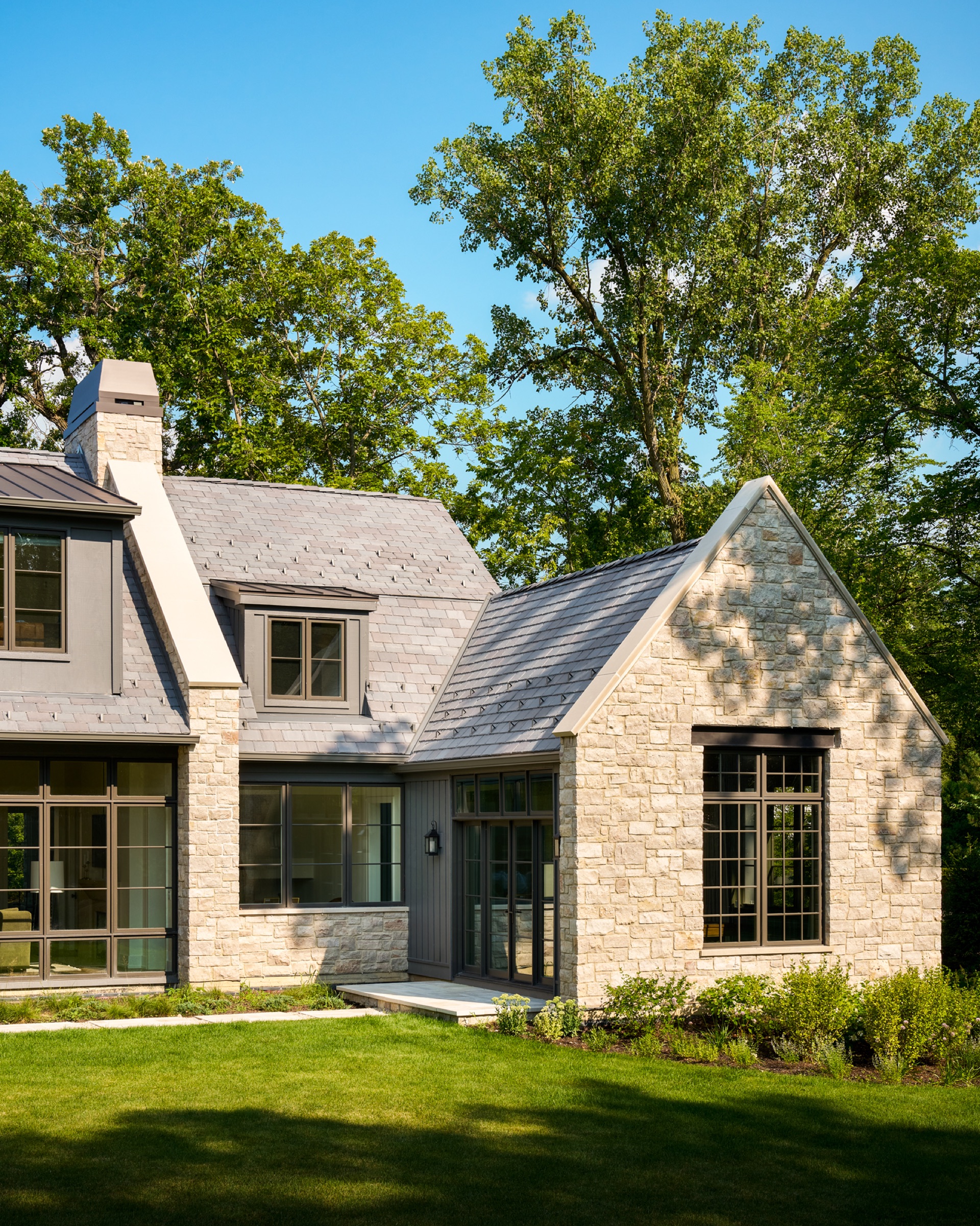The back facade of a custom-designed and built home, revealing an English cottage architectural style.