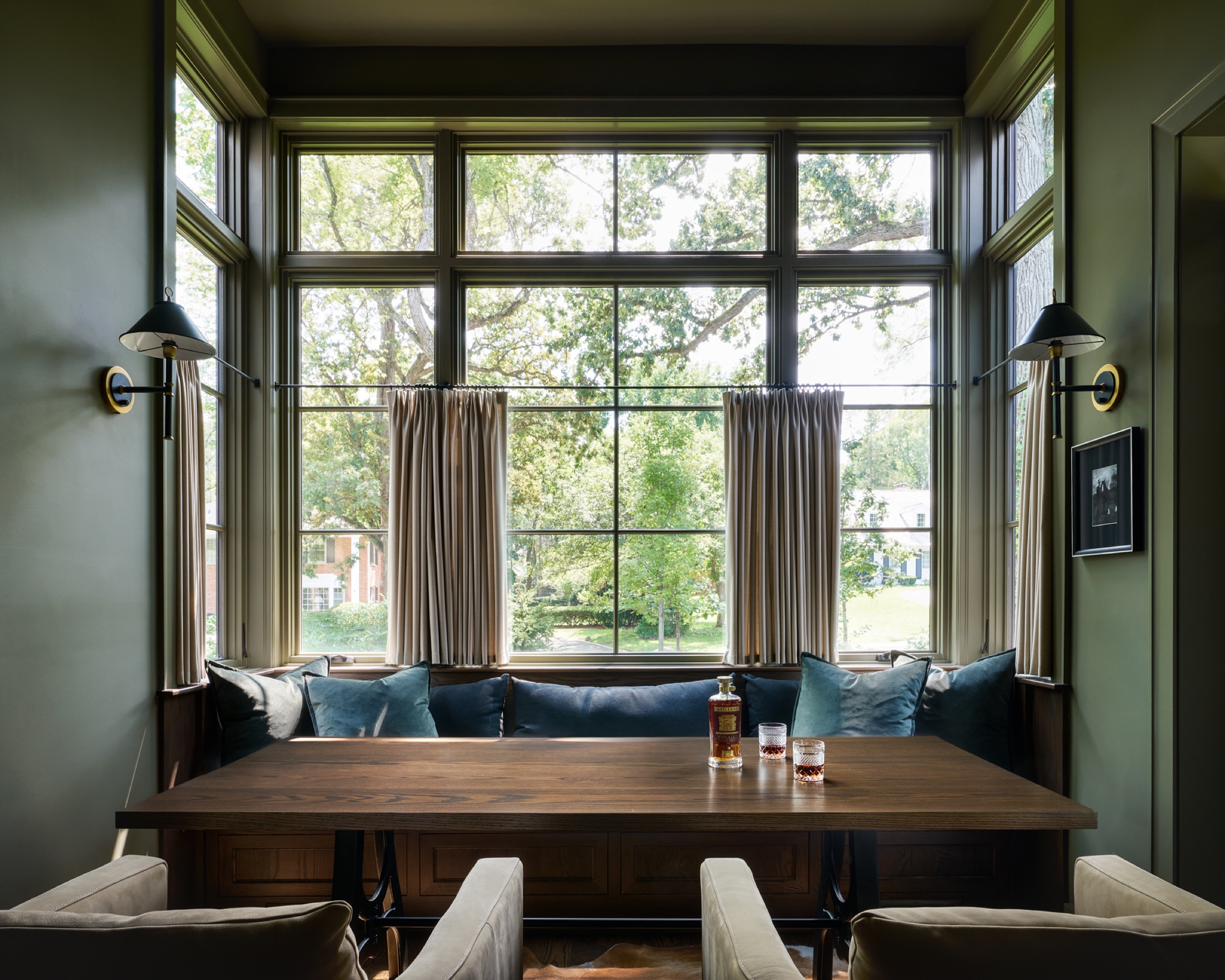 A hidden speakeasy off the billiards room, featuring gorgeous transom windows, a built-in seating area, and intricate trim and molding details.