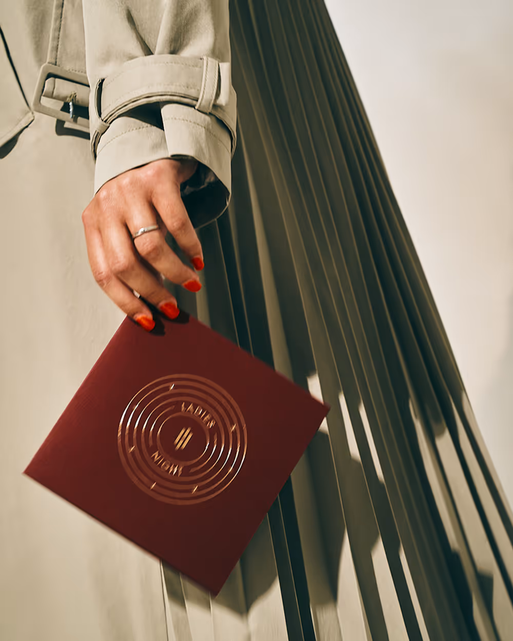Frau im Mantel präsentiert das gestaltete Plattencover für "Ladies Night".