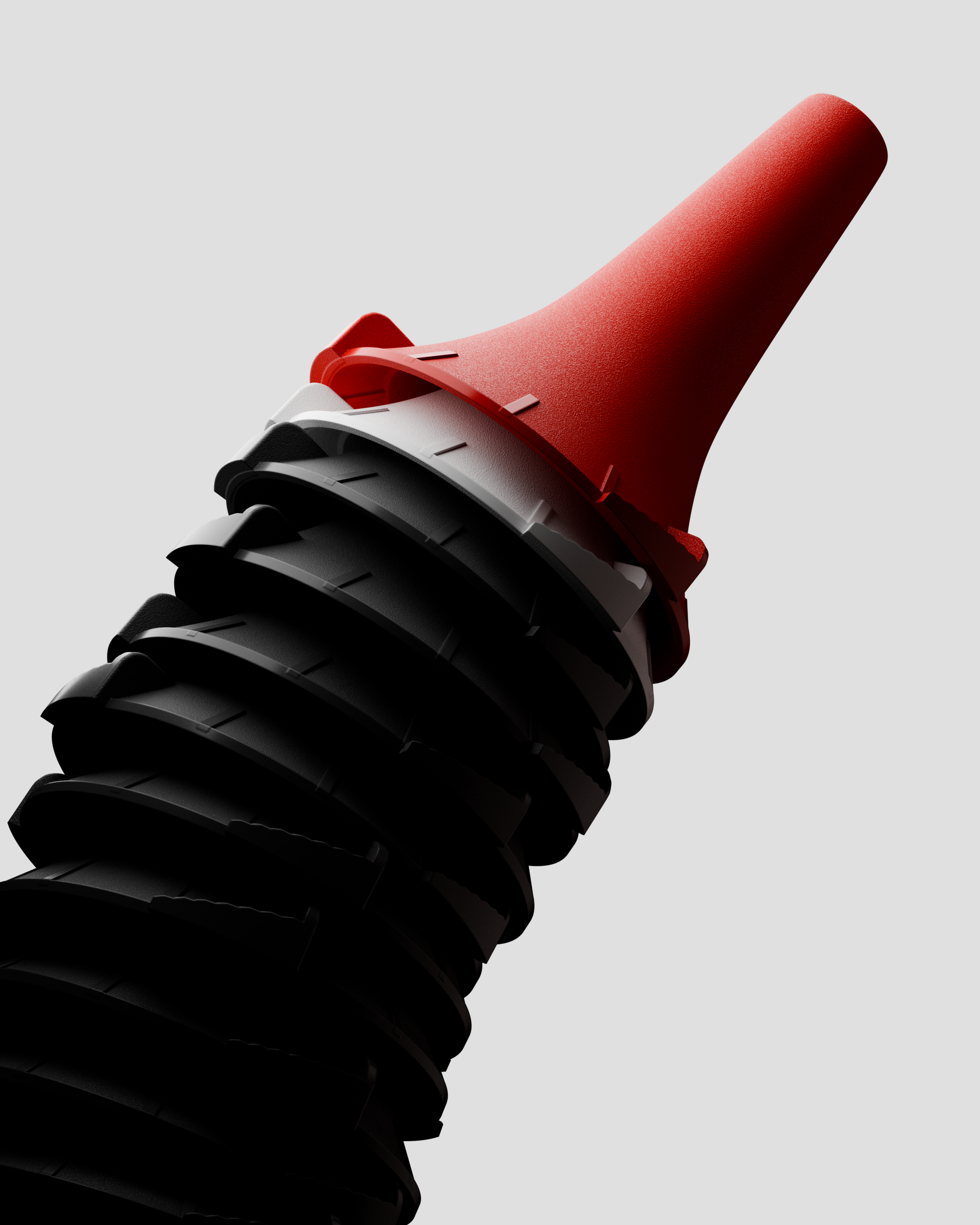 Stack of black and white plastic cones with a red cone on top against a light gray background.