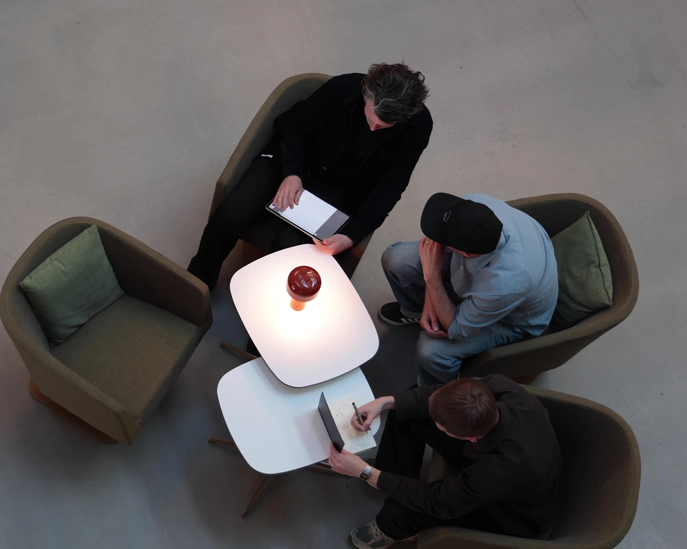 Designer reaching for a book in the studio library while a colleague walks past blurred in the foreground.
