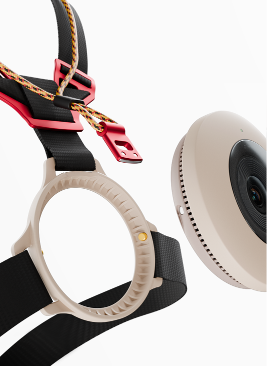 Beige circular device with lens separated from a black strap with red clips on a white background.
