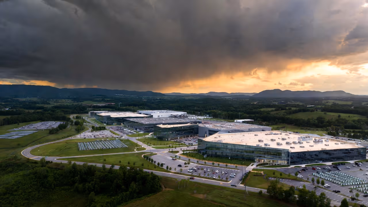 Aerial view of modern manufacturing campus with dramatic storm clearing