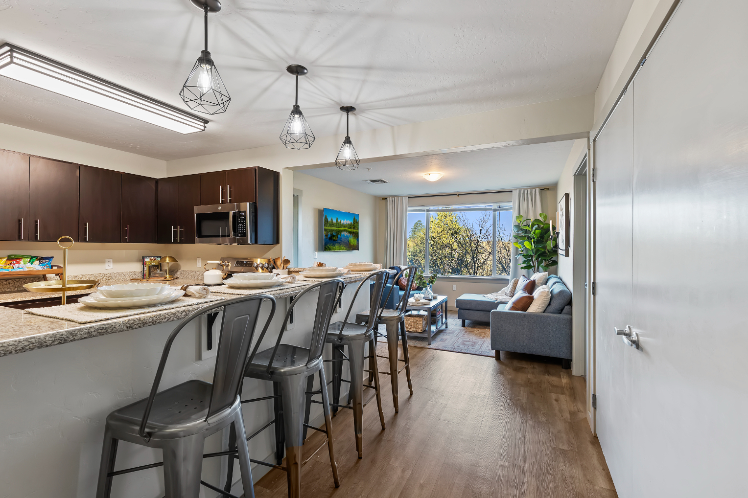 Kitchen with island and stools and view into furnished living area