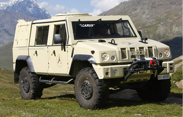 Beige Iveco off-road rescue vehicle named 'ICARUS' parked on grass with mountains in background.