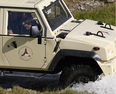 Beige Protezione Civile Nazionale vehicle crossing shallow water with two people inside.