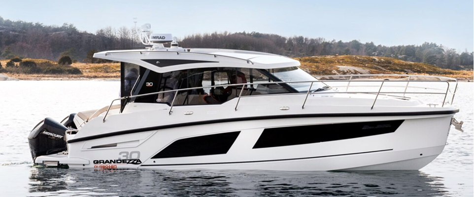 White Grandezza 30 motor yacht with black windows sailing on calm water near forested shore.