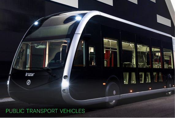 Modern black public transport bus with large windows parked near a building at night.