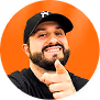 Smiling man with a beard and black cap giving a thumbs up against an orange background.