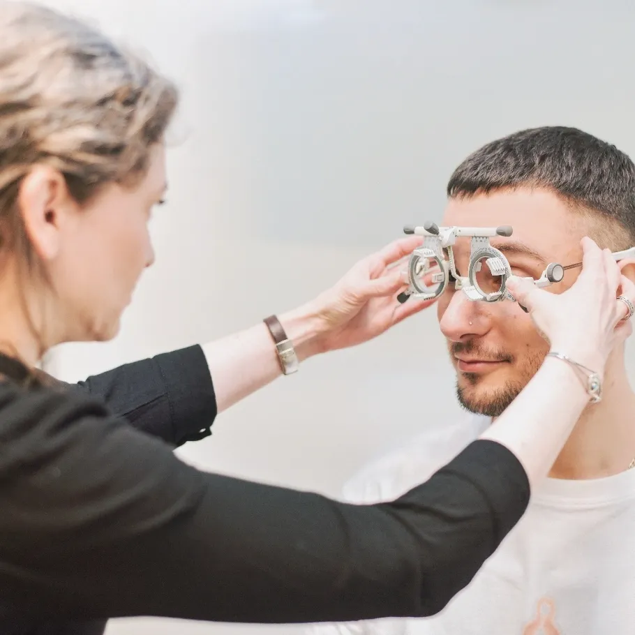 Optikerin passt einem Mann eine Brille bei einem Sehtest an.