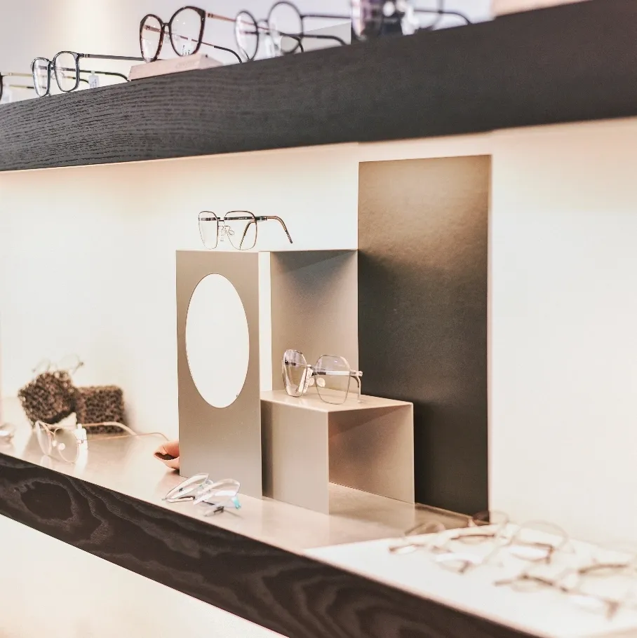 Elegante Brillen auf minimalistischem Verkaufsdisplay mit weißem und schwarzem Hintergrund.