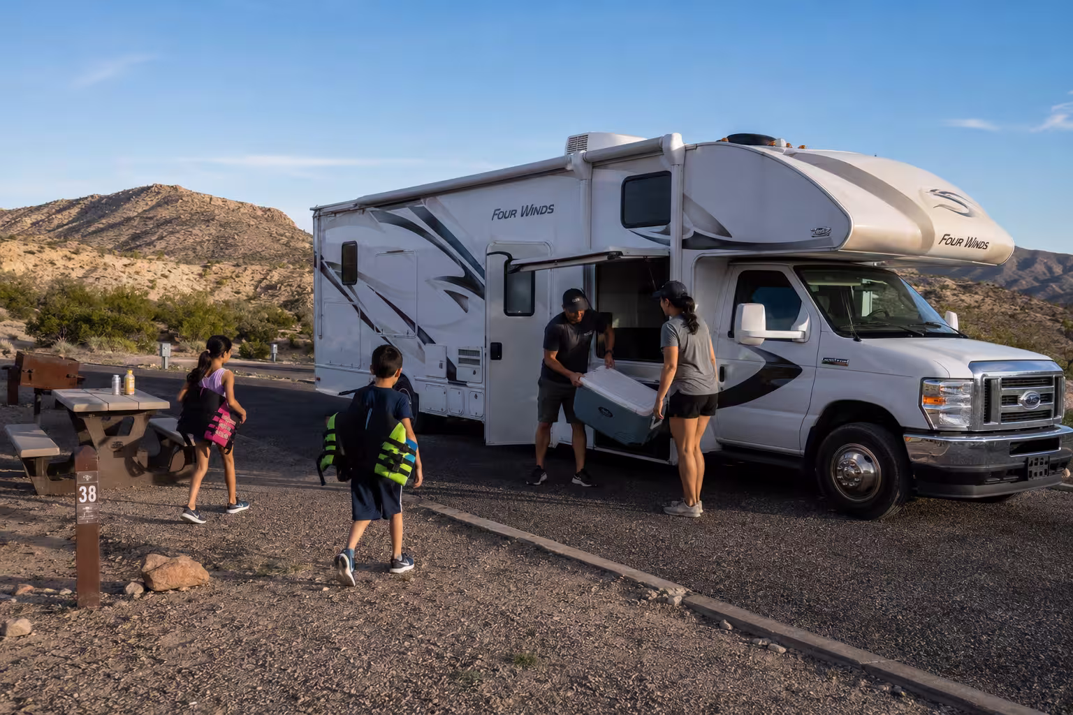 Family unloading a Class C rental at an Elephant Butte campsite