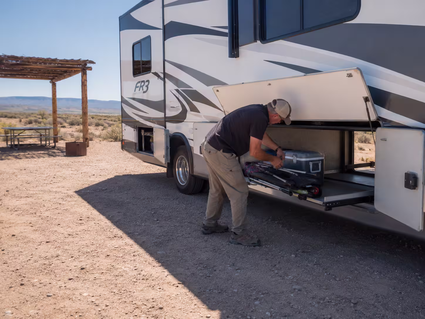 Loading lake gear into Class A motorhome storage bays in Elephant Butte