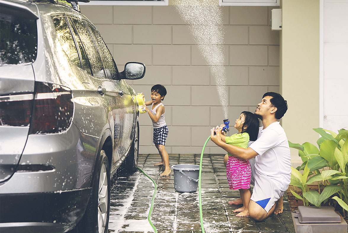 Father washing car with his children