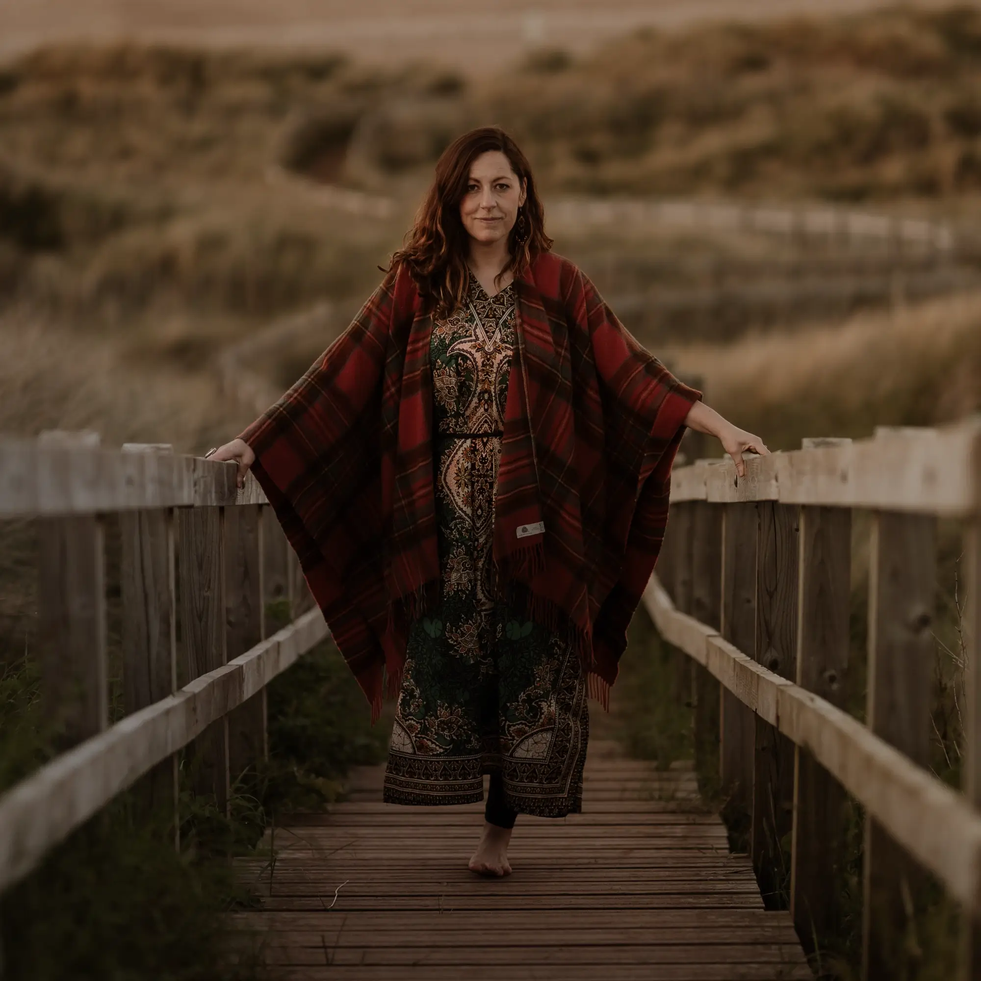 Dawn wearing a red shawl and walking up from the beach