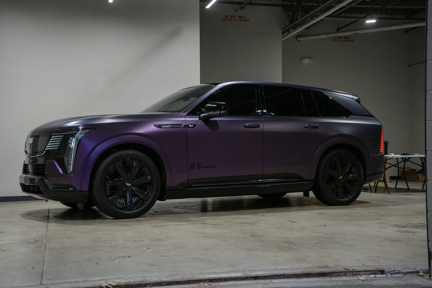 Satin purple electric SUV with black wheels parked indoors