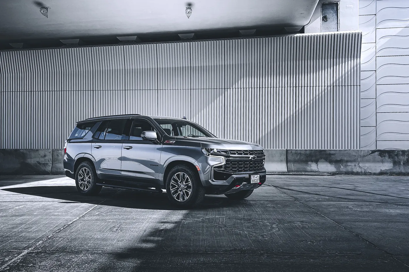 Gray full-size SUV with a glossy finish parked in open shade