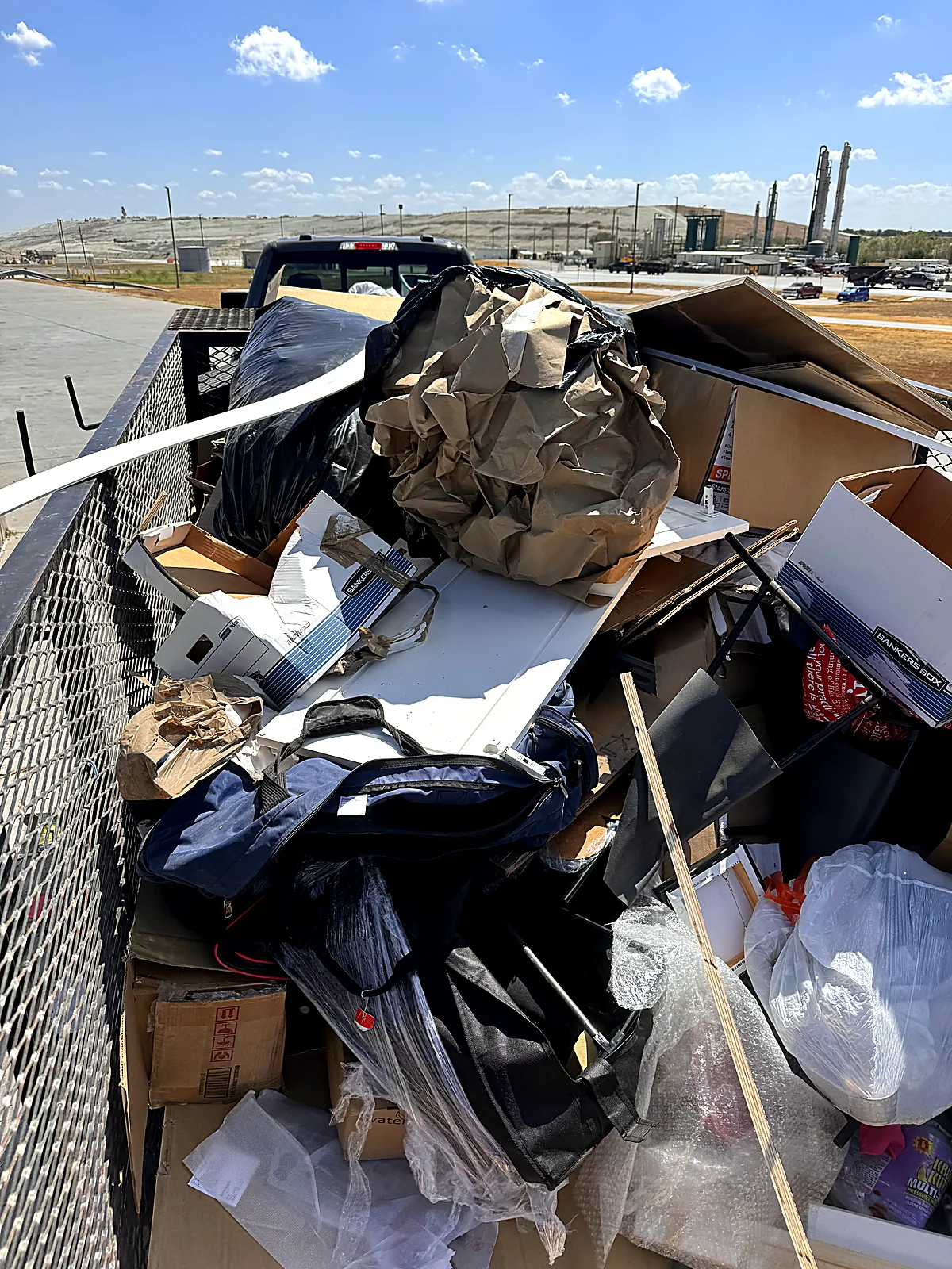 Trailer packed efficiently with bagged household junk and cardboard ready for disposal