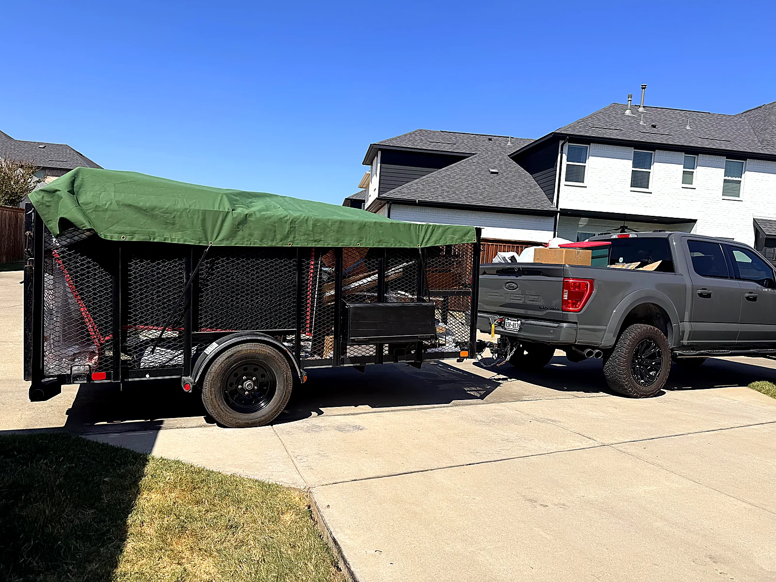 Tarped and secured junk removal trailer ready to leave a Dallas-area property