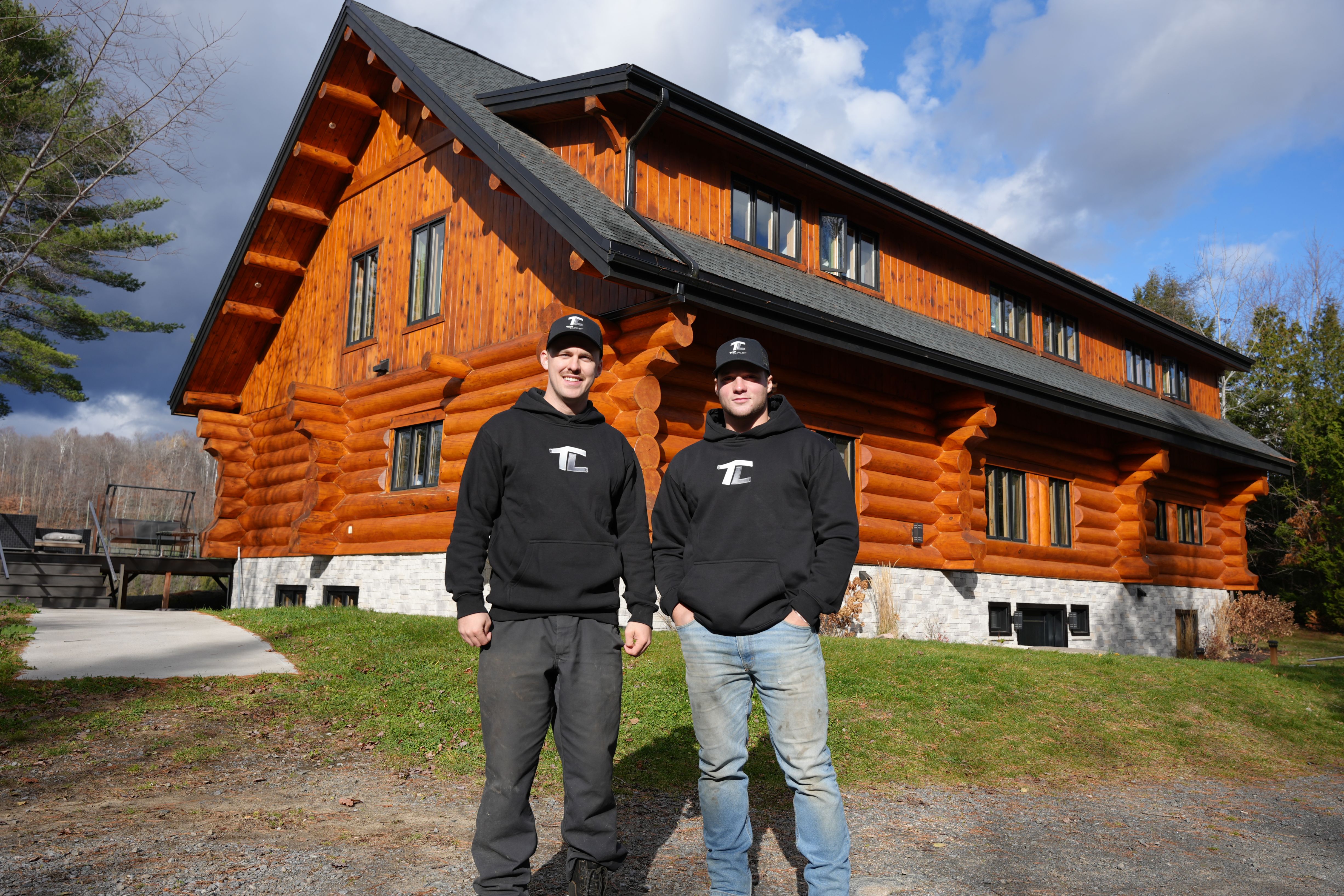 Équipe Top Chalet devant un chalet en bois rond restauré après sablage et teinture