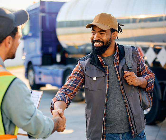 man shaking hand with truck in background