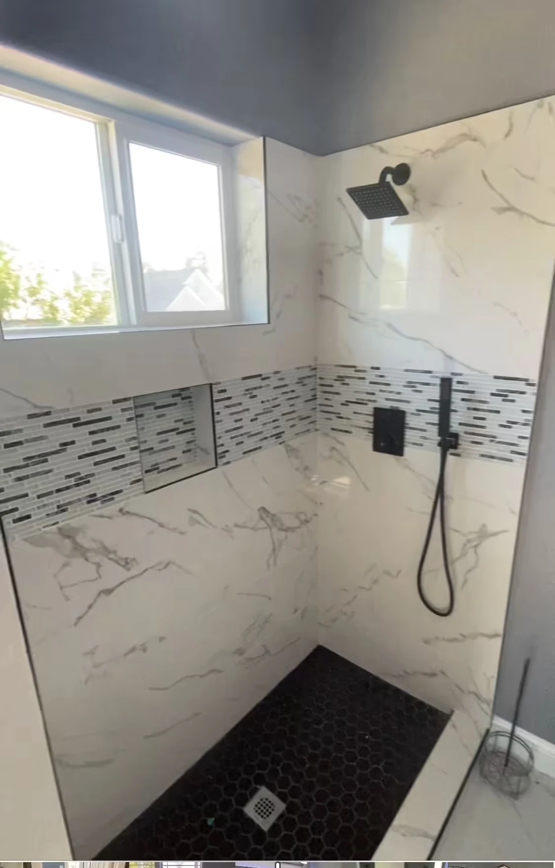 Small modern bathroom with white vanity, black faucet, toilet, bathtub with white shower curtain and black fixtures.