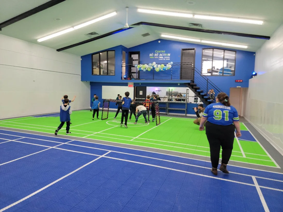 Des jeunes et une animatrice sur le terrain intérieur du Centre Récré-Action