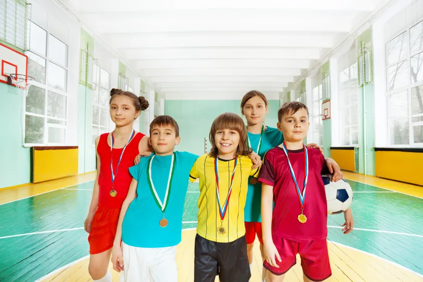 Des enfants avec des médailles dans un gymnase