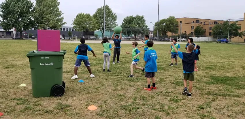 Un groupe de jeunes découvre un jeu sportif en plein air
