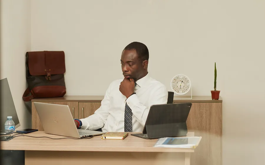 An image of an office desk showing an african man behind the desk