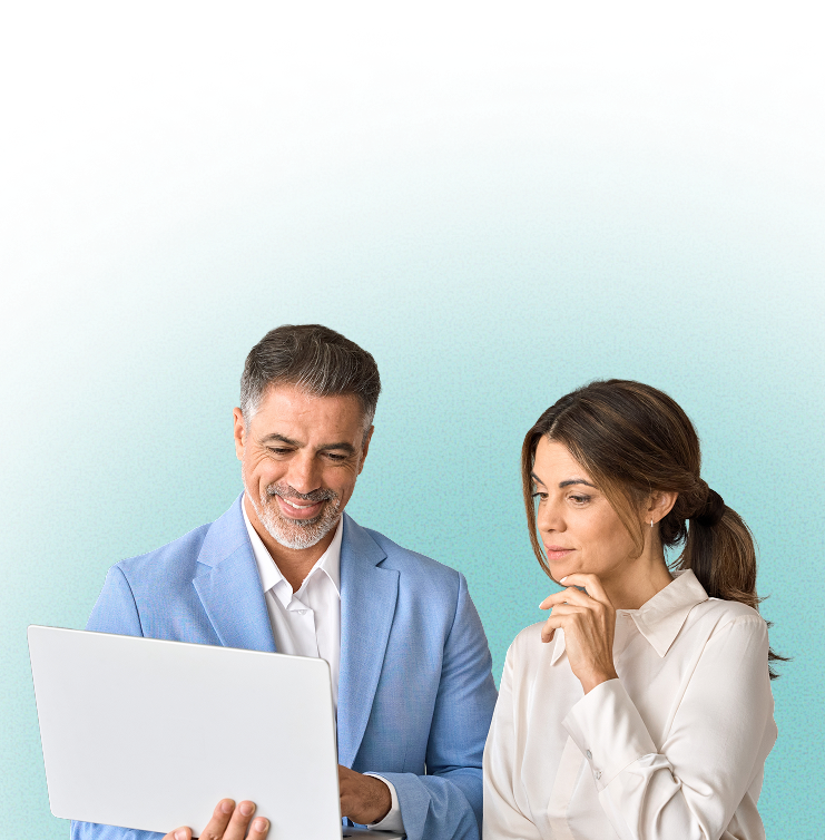 A man in a light blue blazer and a woman in a white blouse looking at a laptop screen together.