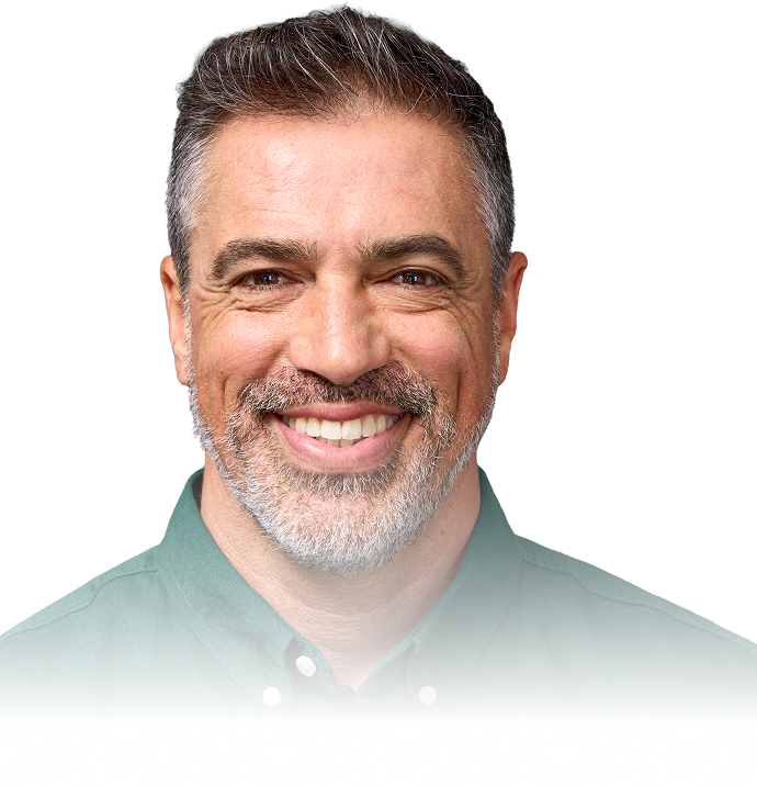 Smiling middle-aged man with gray hair and a salt-and-pepper beard wearing a green collared shirt against a white background.