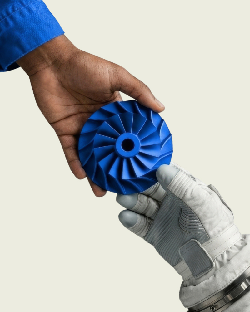 Blue-sleeved hand passing a blue 3D-printed part into an aerospace glove, from Xometry's No Small Parts campaign