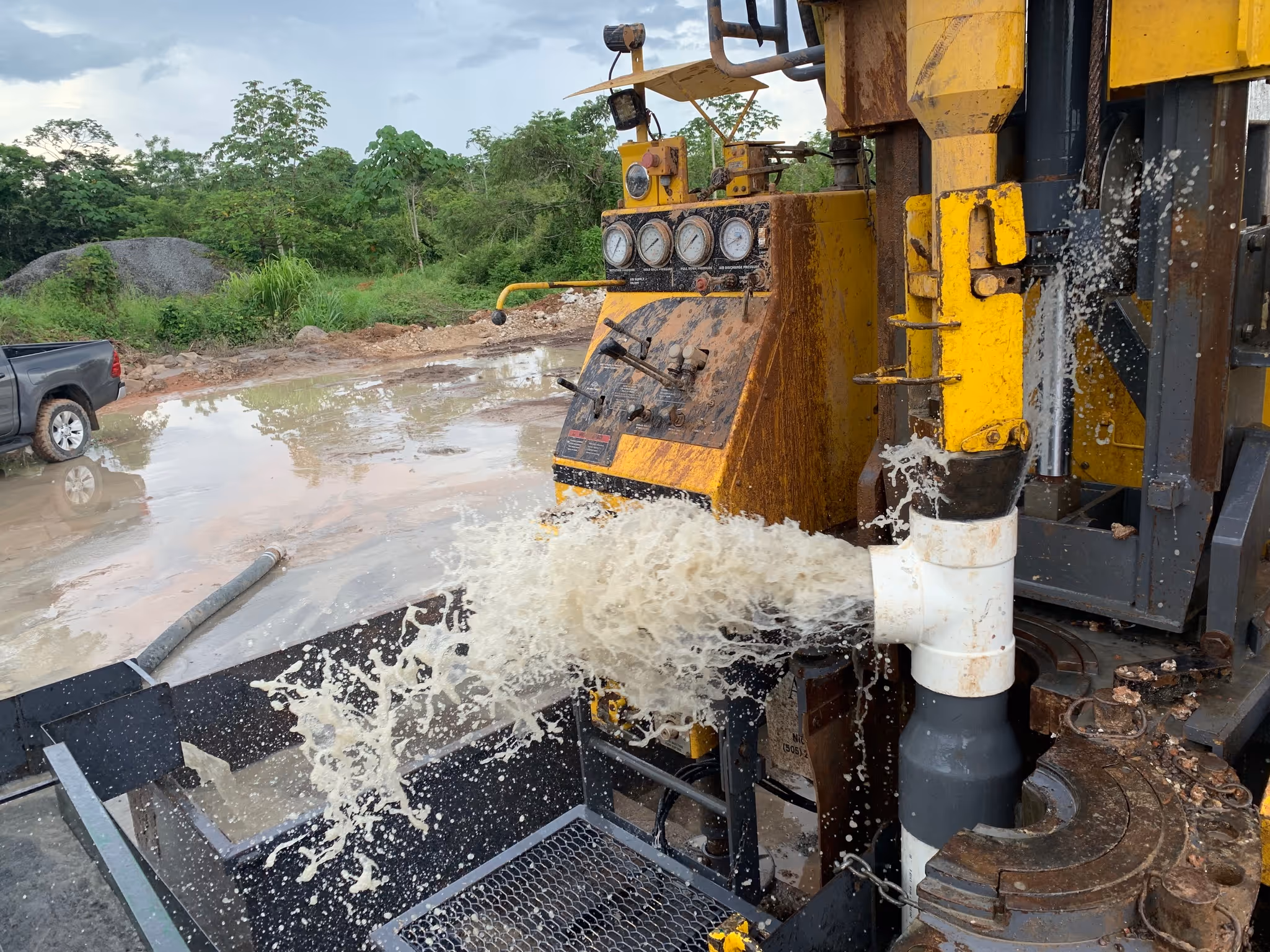 A water well drill struck a vein of water deep underground, it surges to the surfaces and flows from a pipe. The water is collected by the HydroLOGICA machine.