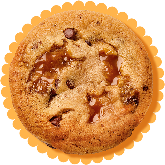 Close-up of a cookie with smooth caramel melted on top and chocolate chips.