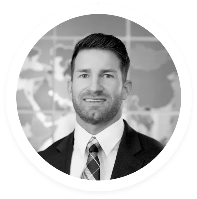 Portrait of a man in a suit and tie with a world map blurred in the background.