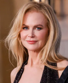 Blonde woman with light makeup wearing a black sequined dress smiling at the camera.