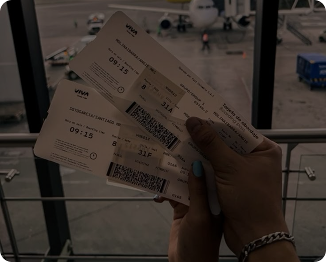 Hands holding three Viva airline boarding passes inside an airport terminal with a plane visible outside the window.