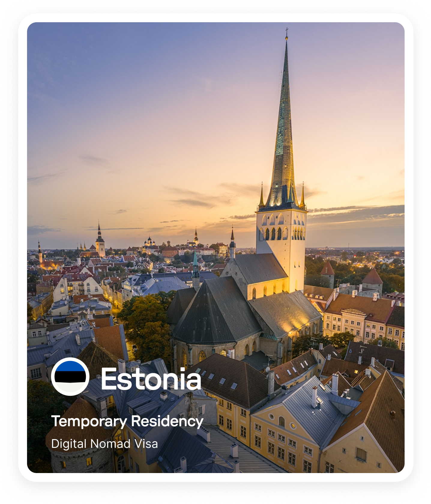 Aerial view of Tallinn, Estonia at sunset with the prominent St. Olaf's Church spire and historic buildings.