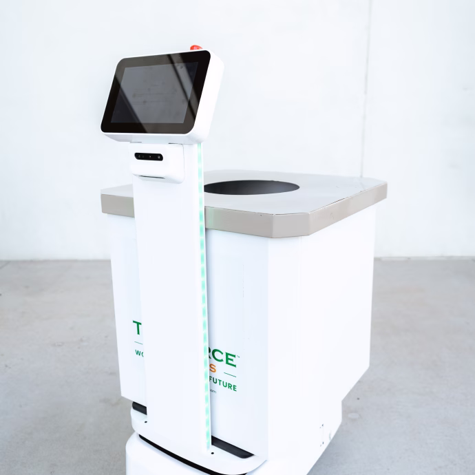 White service robot with a touchscreen on a tall stand and a square storage container with an opening on top.