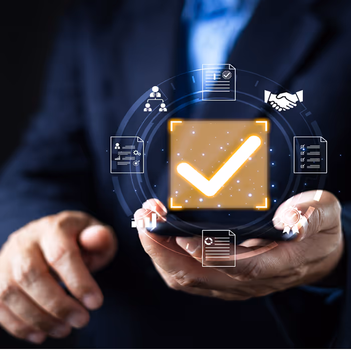 Businessman holding a smartphone displaying a glowing checkmark icon surrounded by digital business and contract icons.