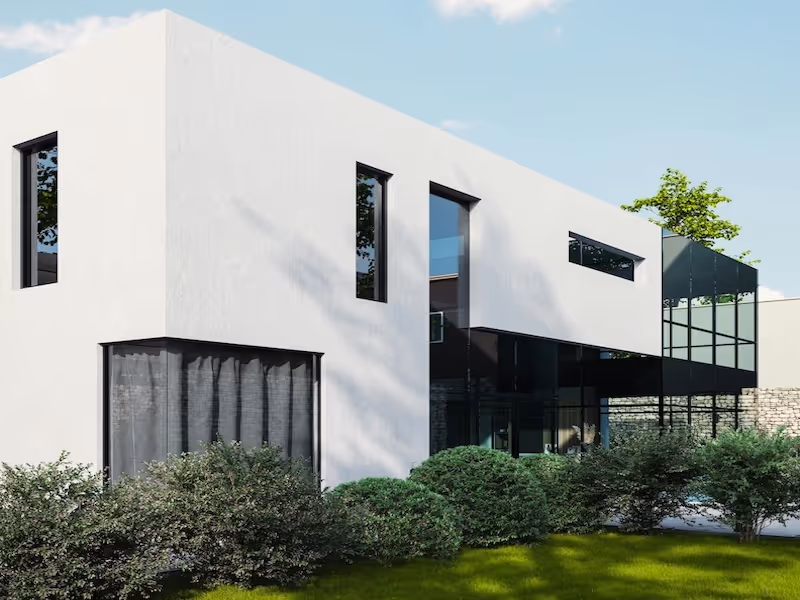 Modern white two-story house with large windows and surrounding bushes on a sunny day.