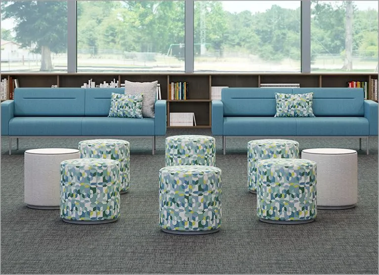 A blue couch with pillows and a blue rug.