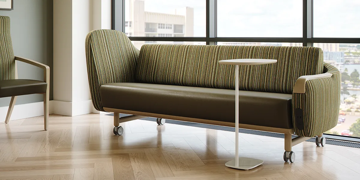 A brown couch with a white table in front of it.
