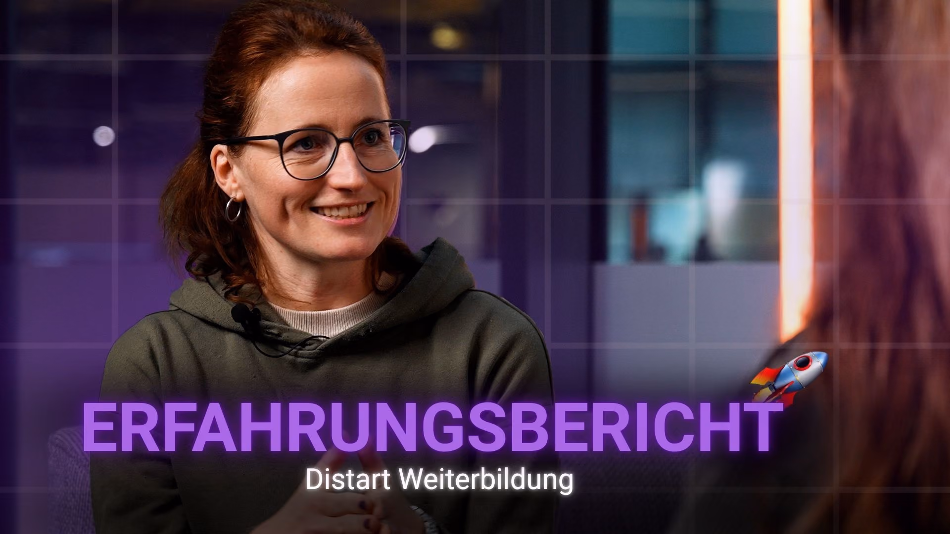 Lächelnde Frau mit Brille und grünem Hoodie in einem Interview mit dem Schriftzug Erfahrungsbericht Distart Weiterbildung.