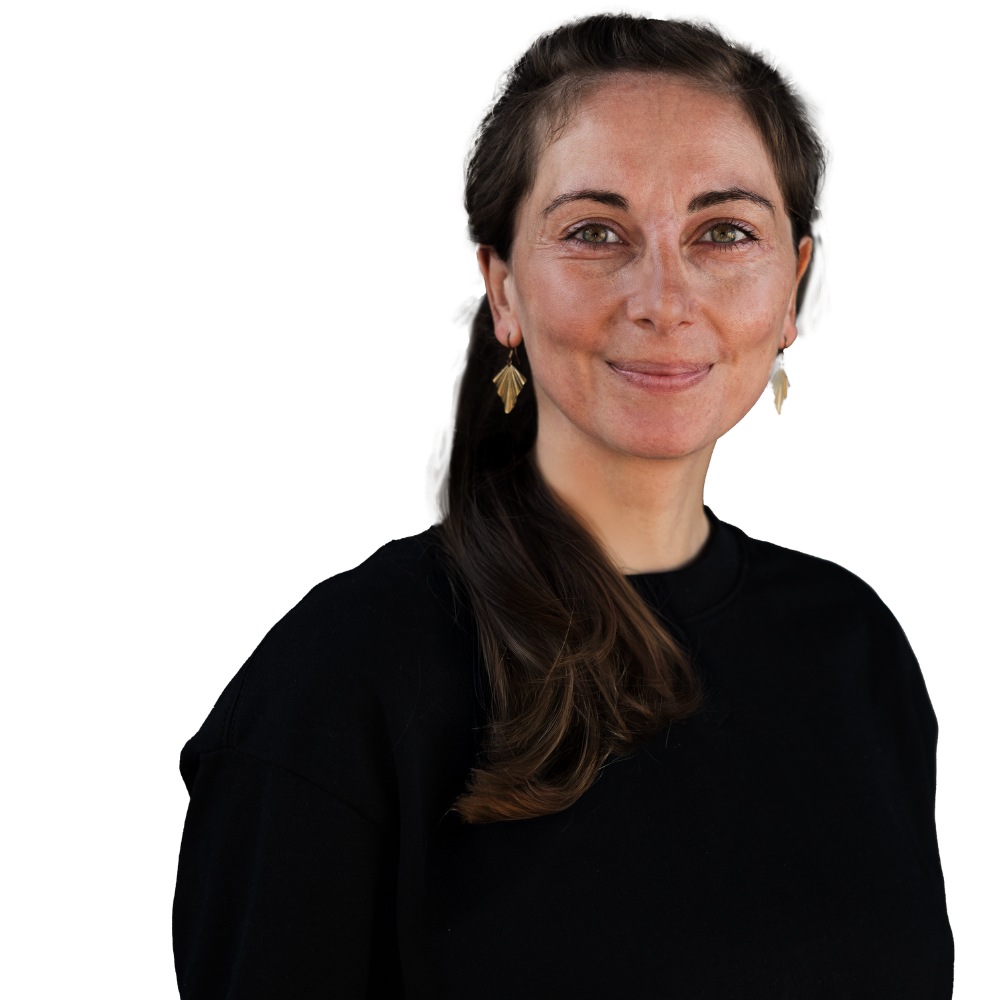 Porträt einer lächelnden Frau mit braunen Haaren, die einen schwarzen Pullover und goldene Ohrringe trägt.