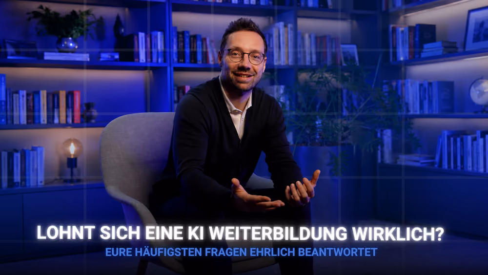 Mann mit Brille sitzt in einem Stuhl vor Bücherregalen in einem blau beleuchteten Raum.