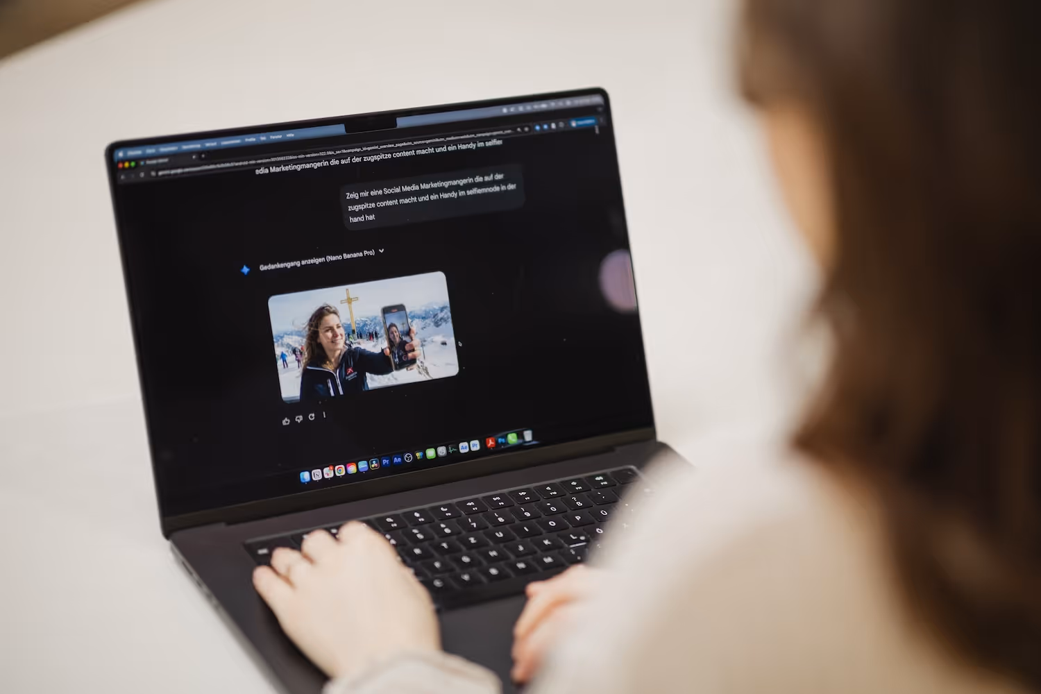 Person arbeitet an Laptop mit Bild von Frau, die Selfie im Schnee mit Handy macht.