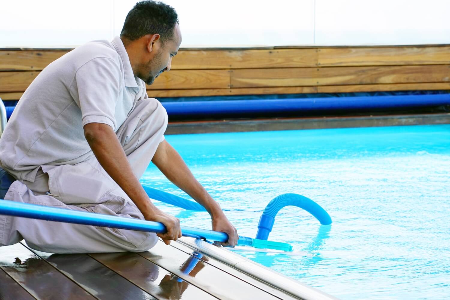 Man working to clean a pool