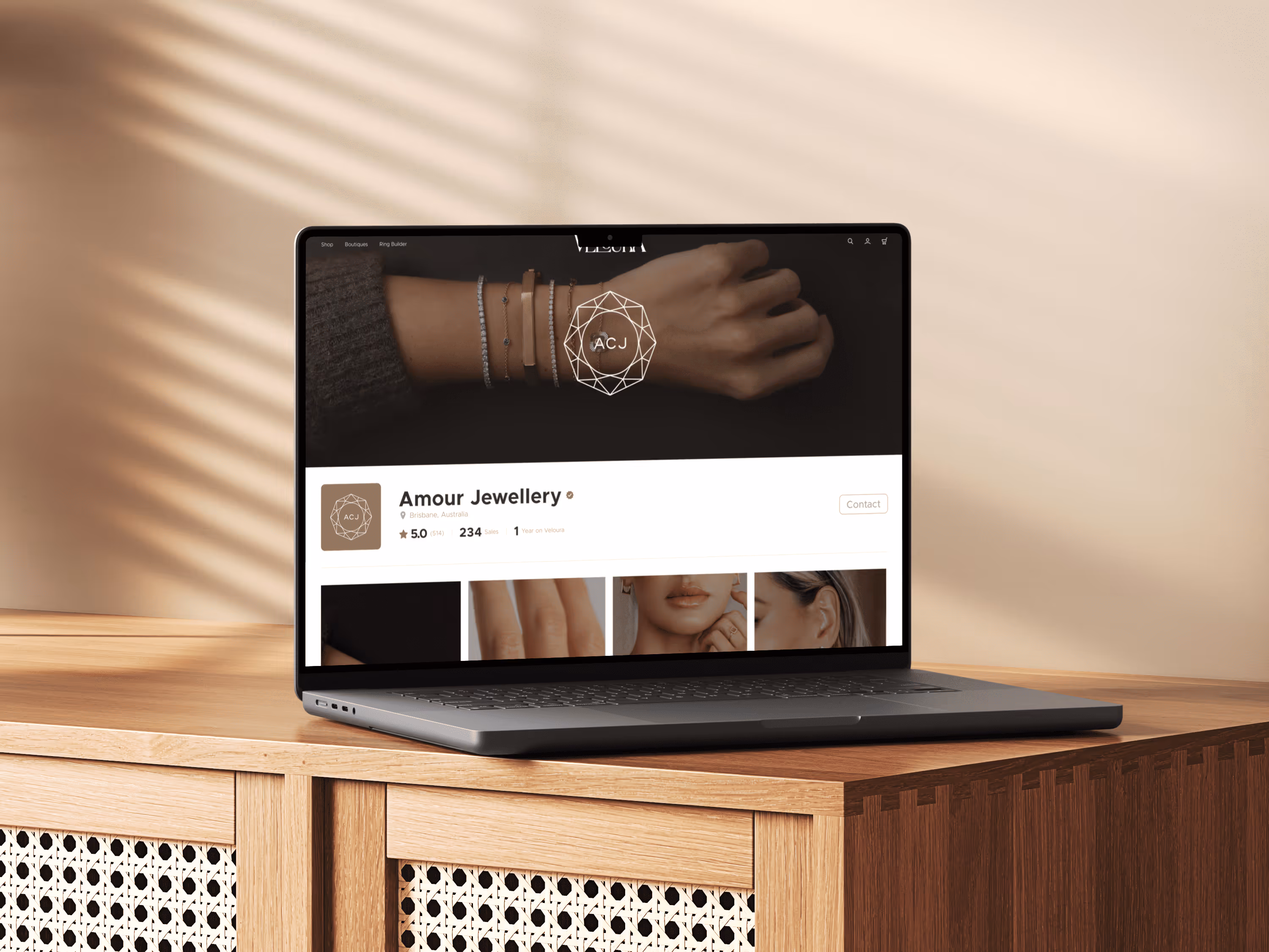 Laptop on wooden desk displaying Amour Jewellery online store with bracelet image on screen.